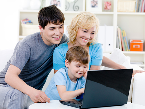 Parents et enfant devant un ordinateur portable