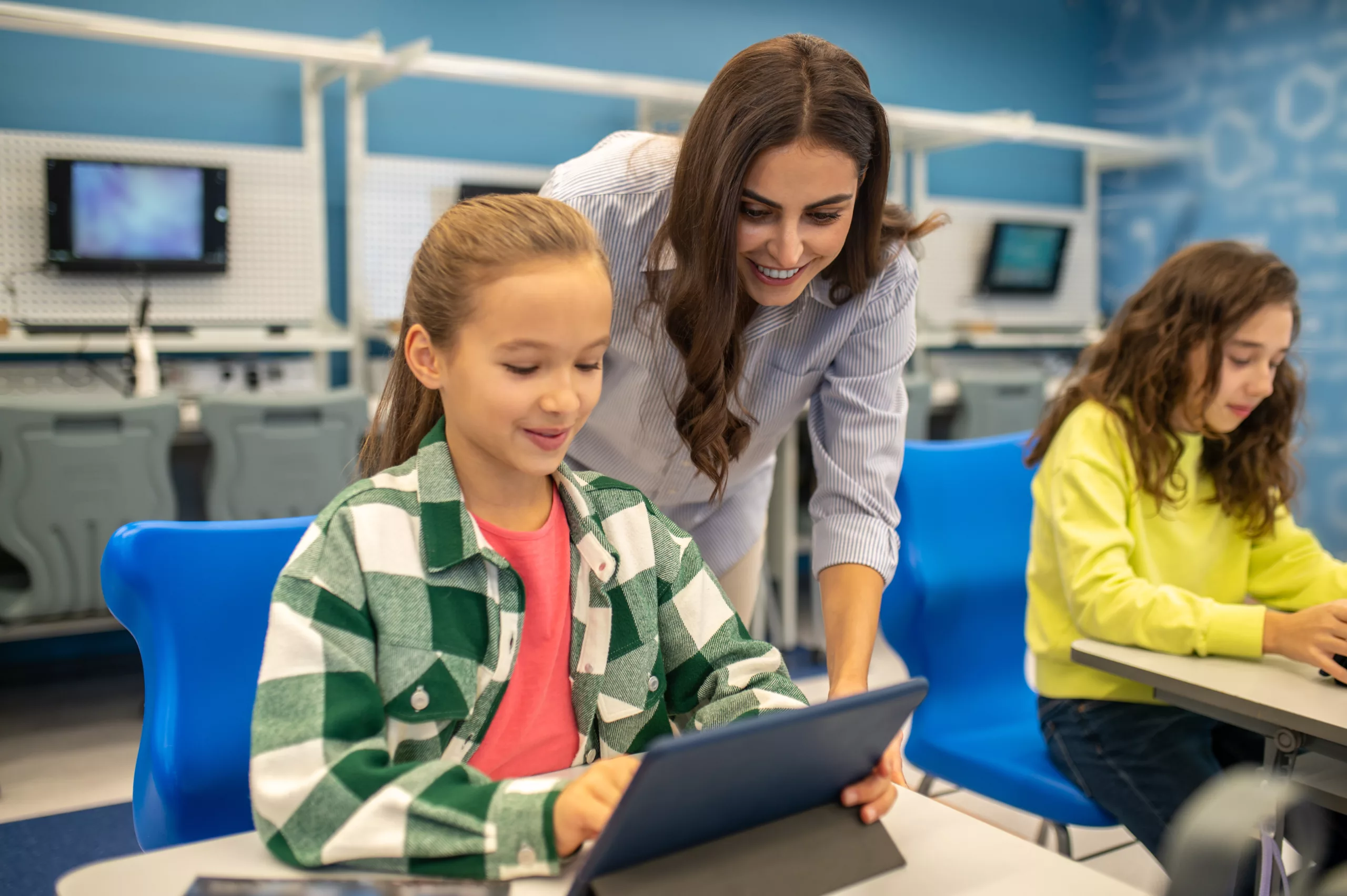 Élèves travaillant sur tablette avec leur enseignante